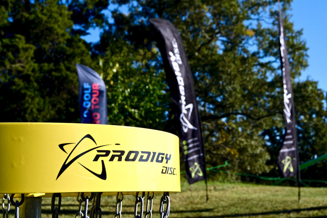 yellow prodigy disc golf basket on a disc golf course